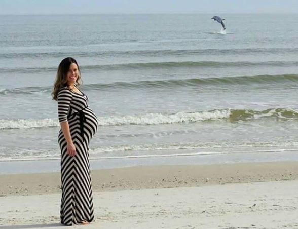 pregnant woman and dolphin jumping in the back