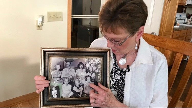 Linda Jourdeans holding up a picture of her family