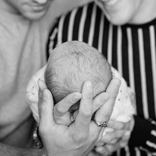 Tom Daley and Dustin Lance Black holding their son