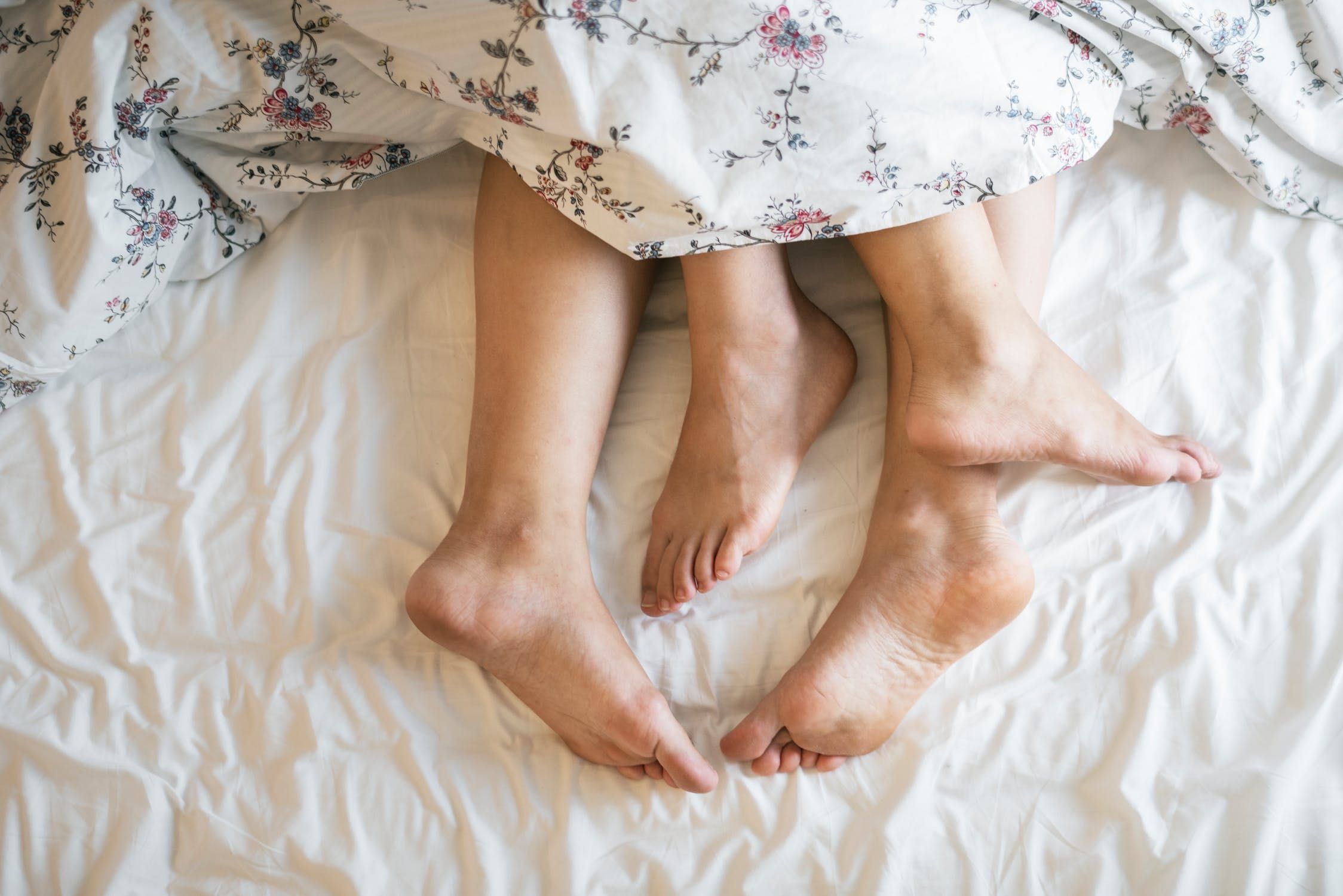 A couple's feet in bed