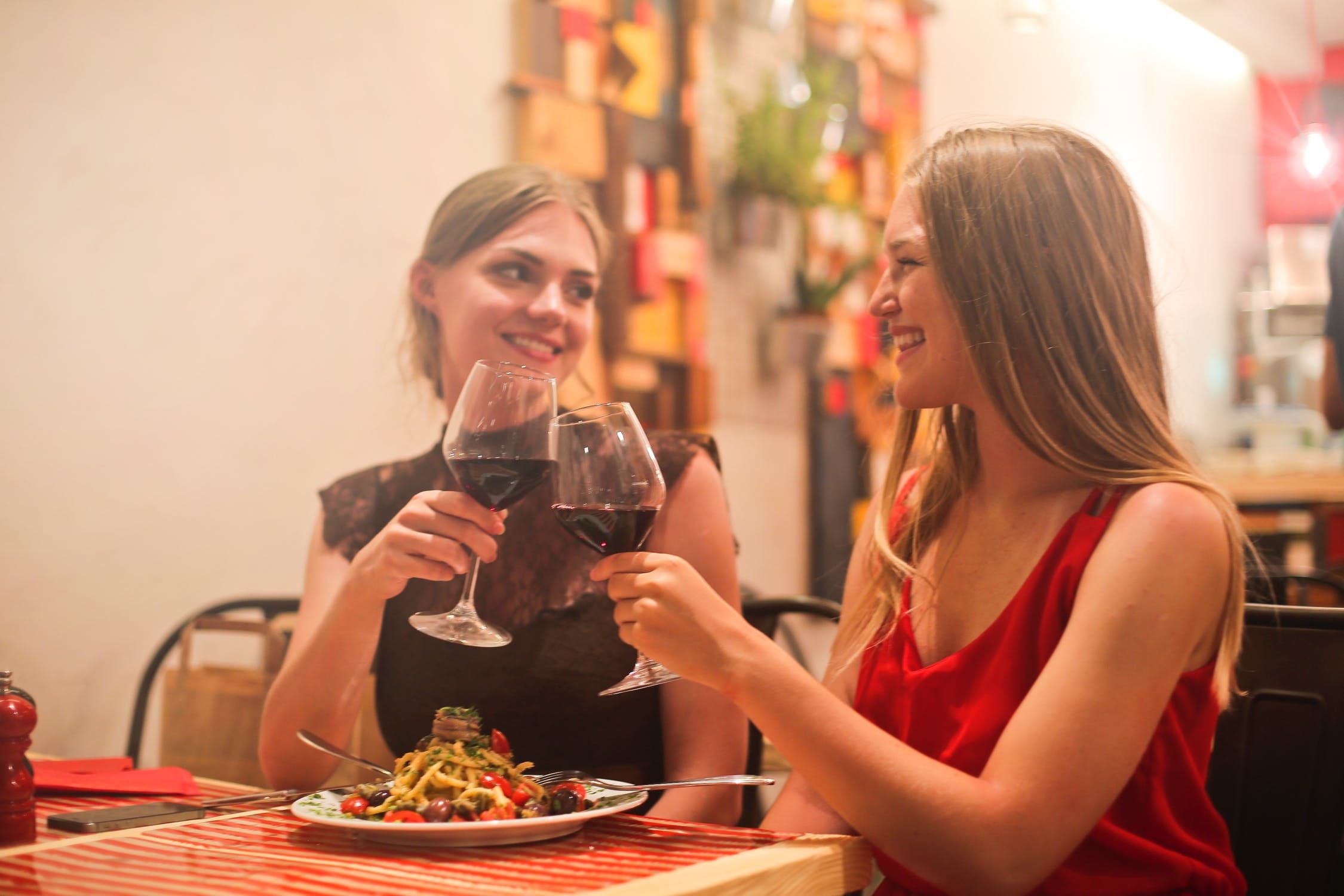 Two women doing a cheers with their wine glasses