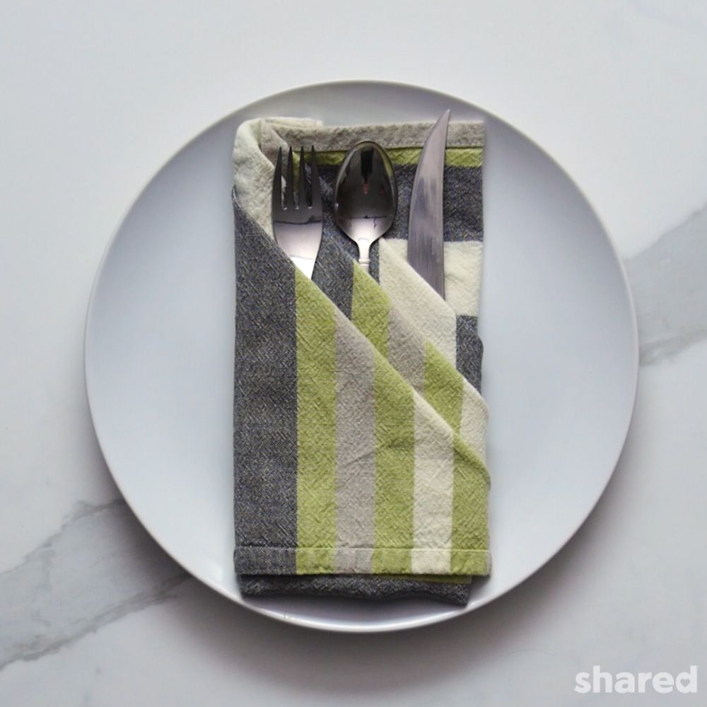 three point pocket napkin fold in stripped grey and green tones silver tableware in pockets