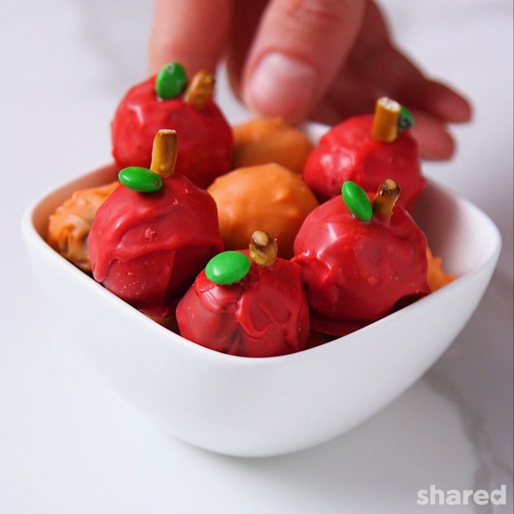 Small truffles in a white bowl that are shaped like apples