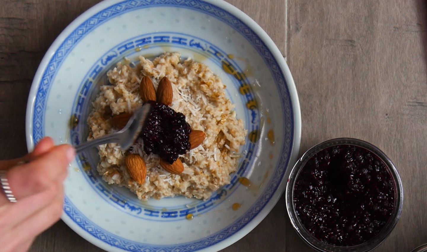 blueberry chia jam being spooned on top of oatmeal