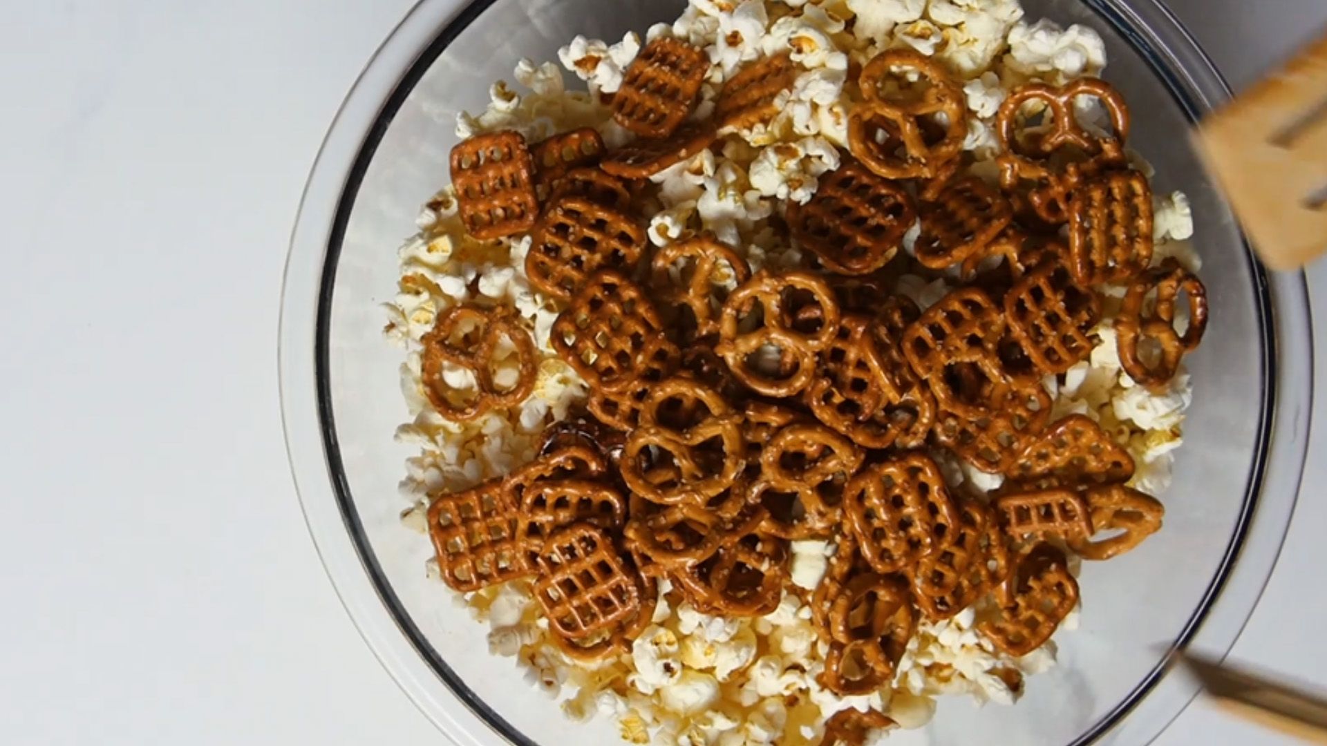 pretzels and popcorn in a glass mixing bowl