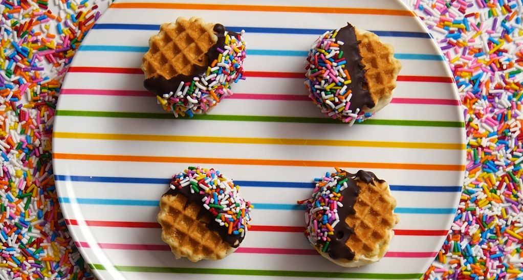 mini waffle wafer ice cream sandwiches on a rainbow stripped serving tray