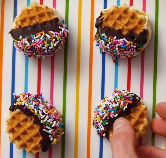 chocolate dipped waffle wafer ice cream sandwiches covered in rainbow sprinkles