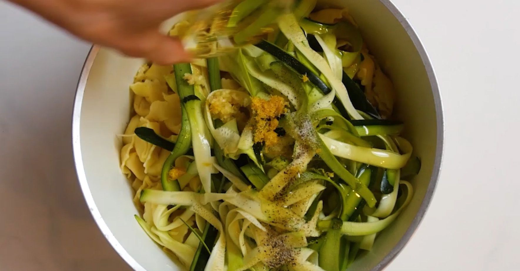 fresh lemon juice and zucchini being added to cooked cheese tortellini