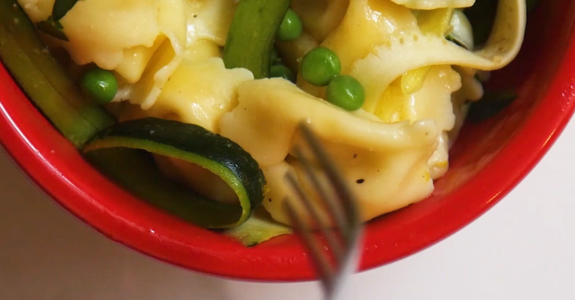 close up of tortellini pasta in a red bowl